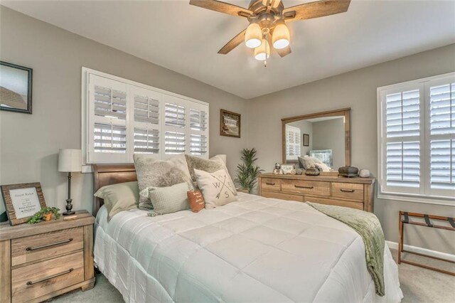 carpeted bedroom featuring a ceiling fan and baseboards