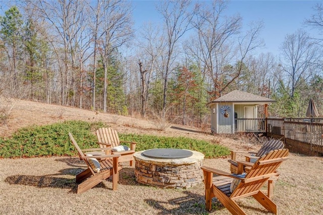 view of yard with an outbuilding, a deck, and an outdoor fire pit