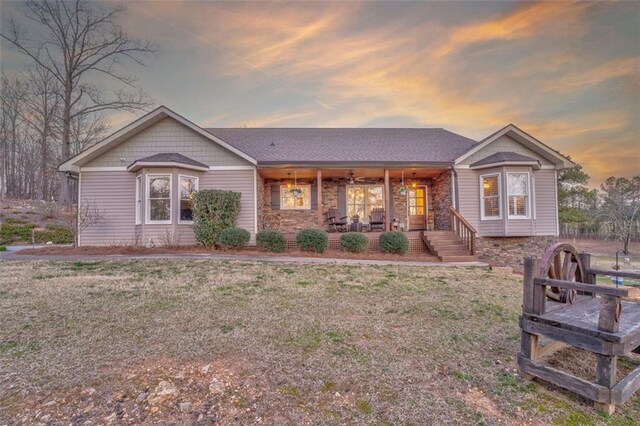 ranch-style home featuring a porch and a yard