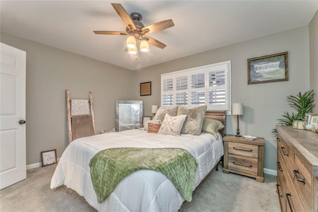 bedroom featuring baseboards, light colored carpet, and a ceiling fan