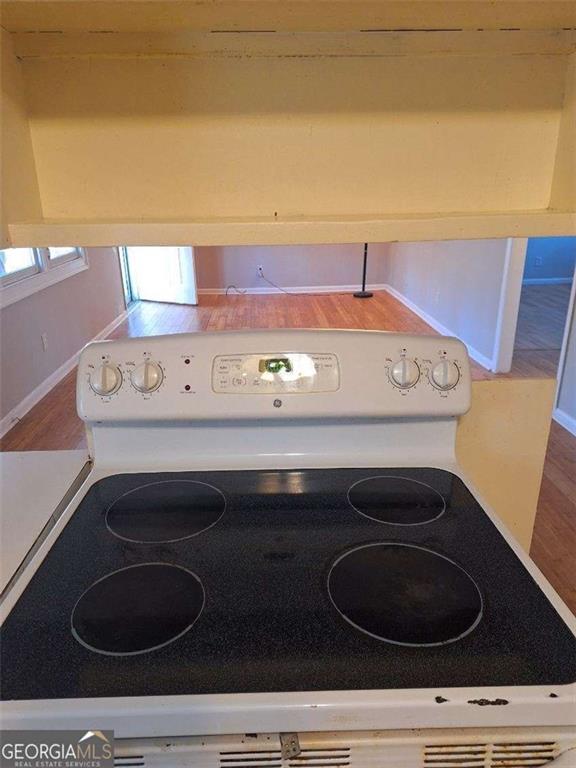 room details featuring white electric stove and wood finished floors