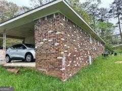 view of home's exterior with an attached carport and brick siding