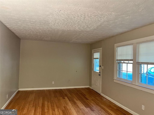 entryway with a textured ceiling, baseboards, and hardwood / wood-style floors