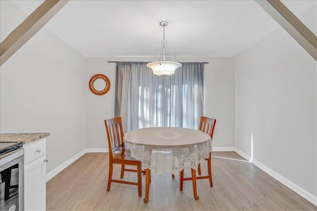 dining area featuring light wood-style flooring and baseboards