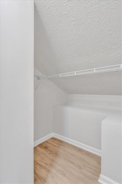 walk in closet featuring lofted ceiling and light wood-style flooring