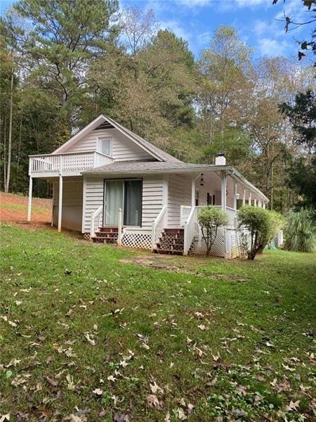 rear view of house with a lawn and entry steps