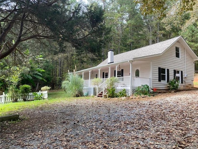 view of front of home featuring covered porch and a chimney