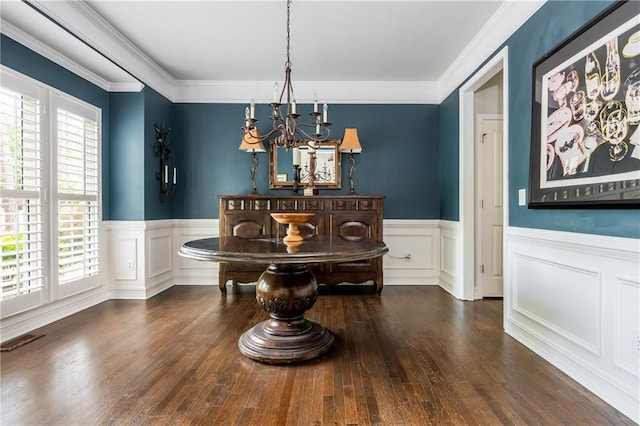 dining area with a chandelier, plenty of natural light, wainscoting, wood finished floors, and ornamental molding