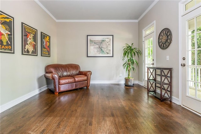 sitting room with wood finished floors, ornamental molding, and baseboards
