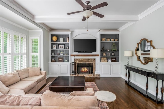 living area featuring wood finished floors, ceiling fan, a fireplace, ornamental molding, and baseboards