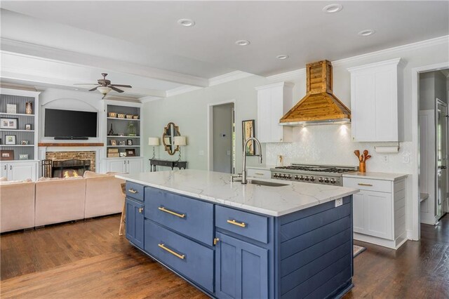 kitchen featuring custom exhaust hood, blue cabinets, a sink, a ceiling fan, and white cabinets