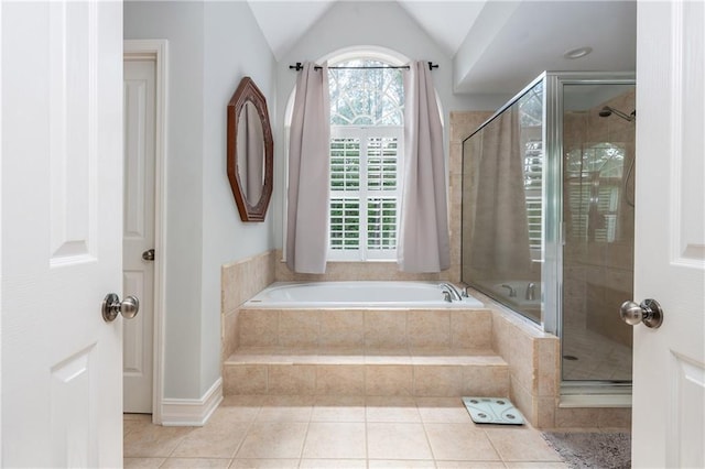 full bathroom featuring a shower stall, a bath, tile patterned floors, and lofted ceiling