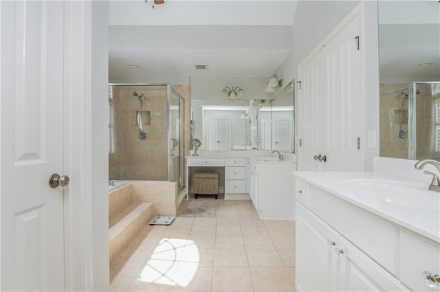 full bathroom featuring a stall shower, tile patterned flooring, a bath, and two vanities