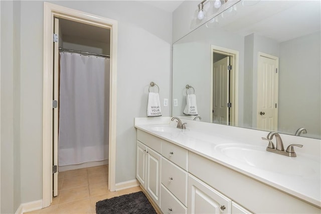 full bath featuring double vanity, tile patterned floors, and baseboards