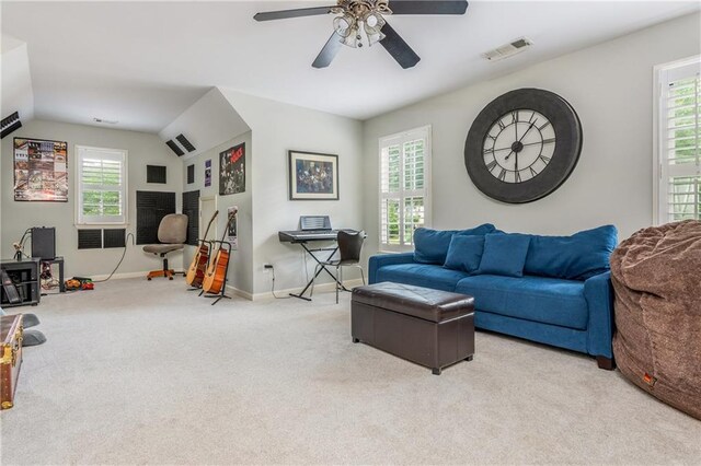 living area featuring carpet, ceiling fan, baseboards, and vaulted ceiling
