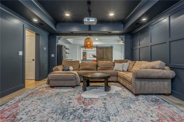 cinema room with light wood-style floors, ornamental molding, and recessed lighting