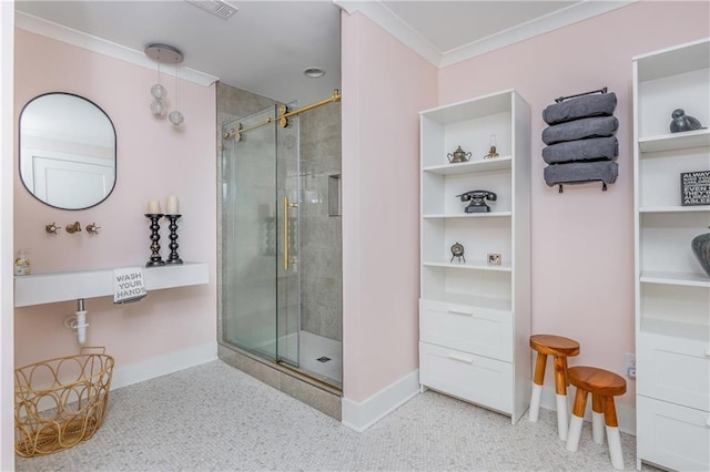 bathroom featuring a shower stall, crown molding, and baseboards