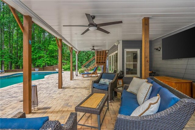 view of patio / terrace featuring an outdoor living space, ceiling fan, an outdoor pool, and stairway