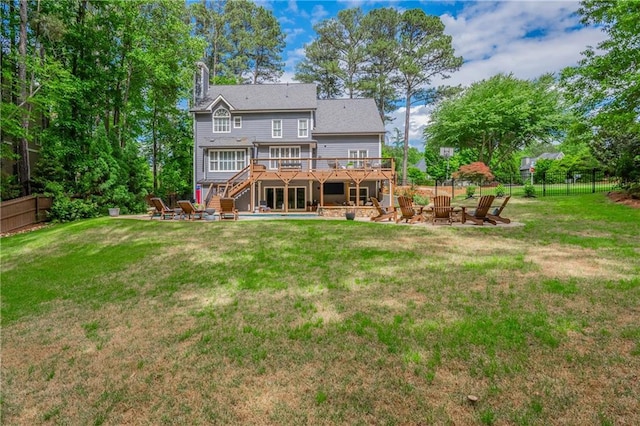 back of house featuring stairway, a deck, an outdoor fire pit, a patio area, and a chimney