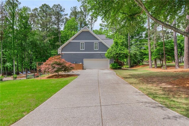 view of front of home with driveway, a garage, and view of scattered trees