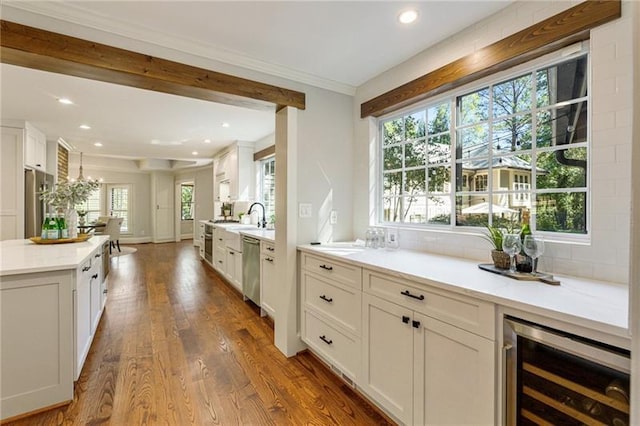 kitchen with dark wood-type flooring, white cabinetry, stainless steel dishwasher, and a center island