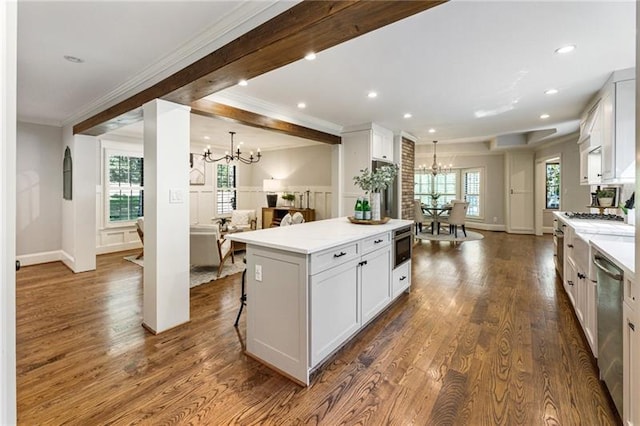 kitchen with a center island, white cabinetry, a kitchen breakfast bar, stainless steel appliances, and beverage cooler