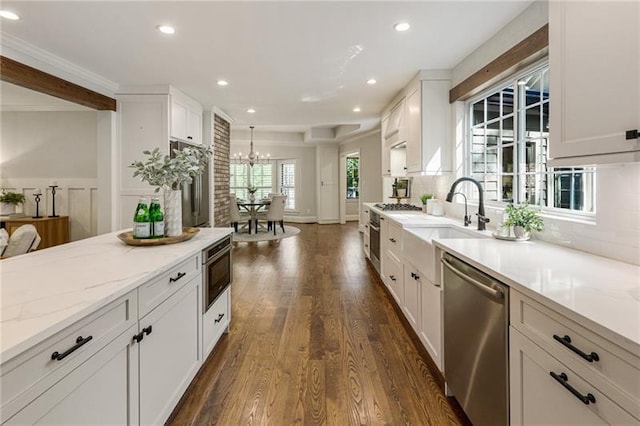 kitchen featuring tasteful backsplash, sink, light stone countertops, stainless steel appliances, and white cabinets