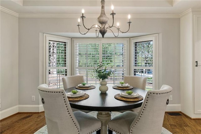 dining space featuring crown molding, hardwood / wood-style floors, and a notable chandelier