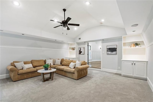 carpeted living room featuring ceiling fan, built in shelves, and vaulted ceiling