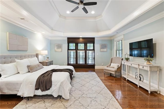 bedroom with ceiling fan, crown molding, dark hardwood / wood-style flooring, and a raised ceiling