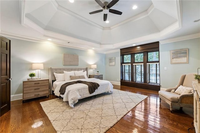 bedroom with ceiling fan, ornamental molding, dark hardwood / wood-style flooring, and a tray ceiling