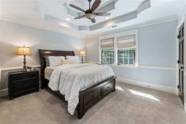 carpeted bedroom featuring ceiling fan, a tray ceiling, and crown molding