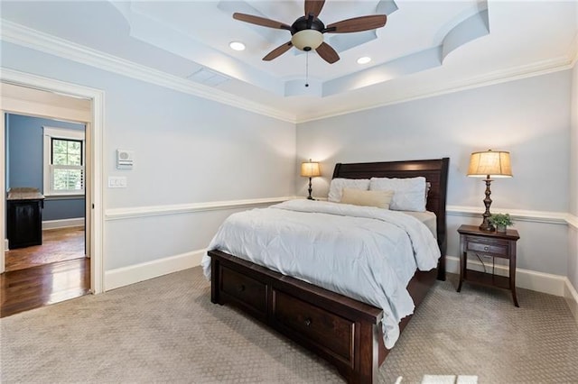 bedroom featuring ceiling fan, light carpet, ornamental molding, and a raised ceiling