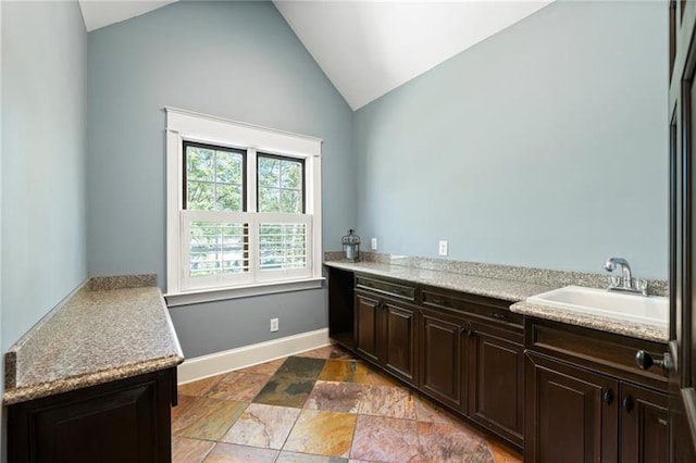 bathroom featuring vaulted ceiling and sink