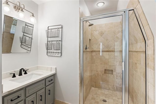 bathroom with a shower with shower door and vanity