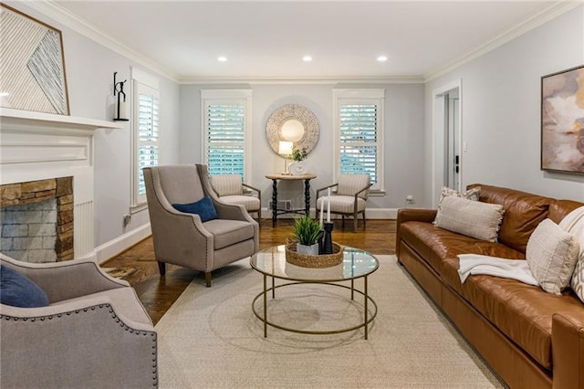 living room with ornamental molding, hardwood / wood-style flooring, and a stone fireplace