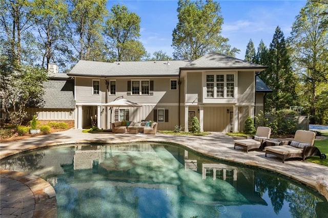 rear view of property with a patio area and outdoor lounge area