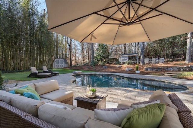 view of swimming pool featuring a shed, an outdoor living space, and a patio area