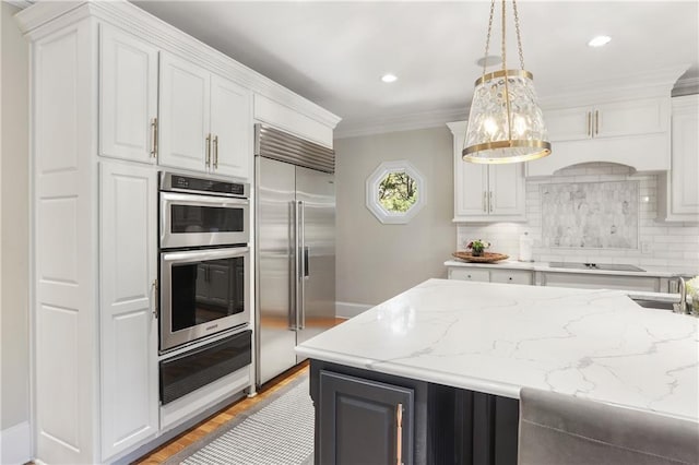kitchen with a warming drawer, white cabinets, light stone counters, and stainless steel appliances