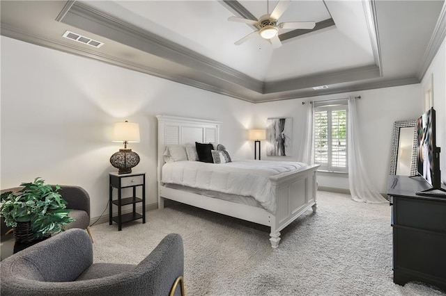 bedroom featuring crown molding, light carpet, a raised ceiling, baseboards, and visible vents