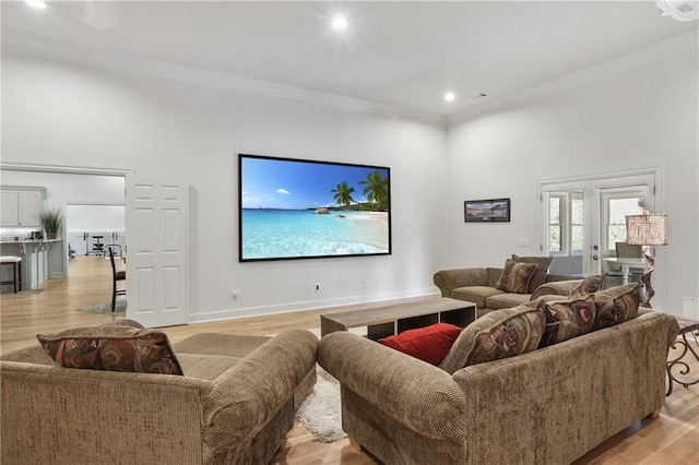 living room featuring light wood-type flooring, a high ceiling, recessed lighting, and crown molding