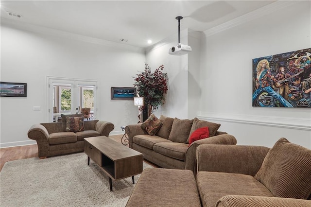 living room featuring light wood finished floors, baseboards, visible vents, recessed lighting, and ornamental molding