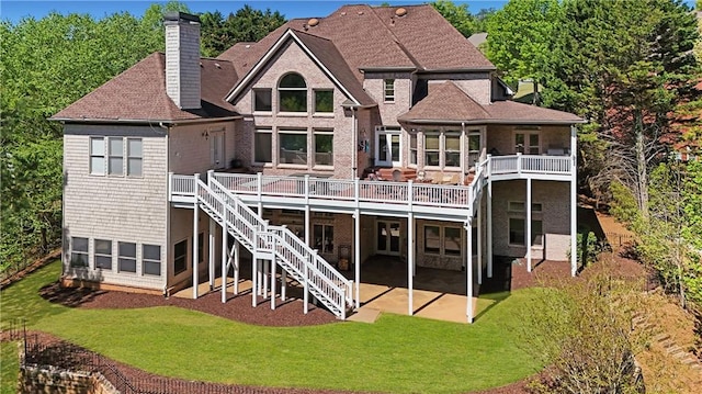 back of property featuring a chimney, a yard, a patio, and a deck