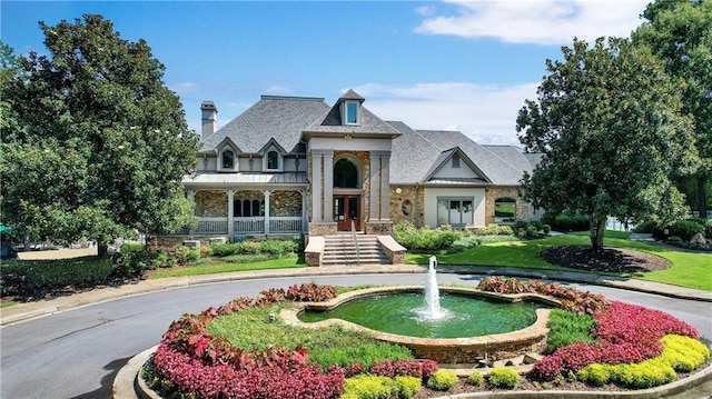 view of front of house featuring stone siding and a front lawn