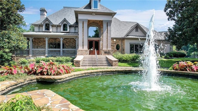 exterior space with a small pond, a chimney, and french doors