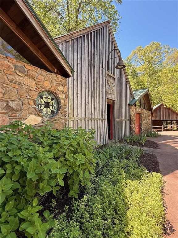 view of home's exterior featuring driveway, stone siding, and board and batten siding
