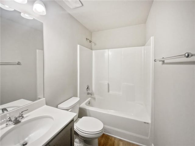 full bathroom featuring hardwood / wood-style flooring, vanity,  shower combination, and toilet