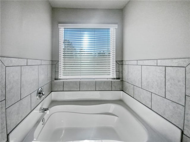 bathroom with a tub to relax in and a wealth of natural light