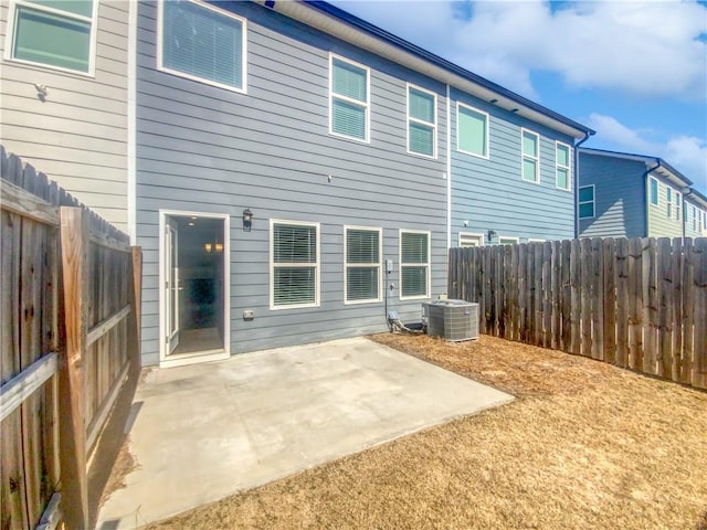 back of property with central AC unit and a patio