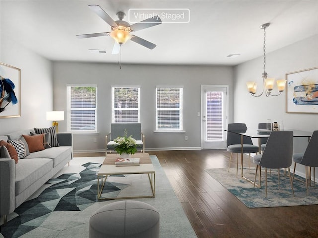 living room with dark hardwood / wood-style floors and ceiling fan with notable chandelier